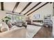 Bright living room boasts exposed beams, a modern fireplace, and expansive windows showcasing the outdoor scenery at 5254 W Oberlin Dr, Denver, CO 80235