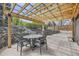 Outdoor patio featuring a pergola, stone wall, mature trees, and an outdoor dining table set at 5254 W Oberlin Dr, Denver, CO 80235