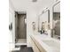Well-lit bathroom with a double vanity, quartz countertop, and glass-enclosed walk-in shower at 4721 Elm Ct, Denver, CO 80211