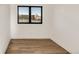 Bright, minimalist bedroom with hardwood floors, a large window, and neutral tones at 4721 Elm Ct, Denver, CO 80211