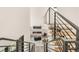 Open living room with modern fireplace, stylish seating, and staircase with metal railings at 4721 Elm Ct, Denver, CO 80211