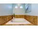 A luxurious soaking tub with tiled surround and bright lighting makes for a relaxing bath at 18009 E 47Th Pl, Denver, CO 80249