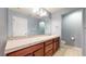 Well-lit bathroom featuring wood cabinetry and a large mirror above a tiled countertop at 18009 E 47Th Pl, Denver, CO 80249