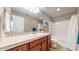 Bathroom with tile countertop, wood cabinets, white sink, and combined bathtub and shower at 18009 E 47Th Pl, Denver, CO 80249