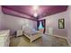 A bedroom with purple walls and carpet features an ornate white bed and an elegant chandelier at 18009 E 47Th Pl, Denver, CO 80249