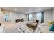 Spacious living room with comfortable seating, soft carpet, and natural light from two large windows at 18009 E 47Th Pl, Denver, CO 80249