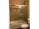 Modern bathroom features a shower-over-tub combination, contemporary tiles, and sleek glass doors at 3345 W Evans Ave, Denver, CO 80219