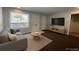Bright living room featuring a modern sofa, stylish coffee table, and flat-screen TV for comfortable living at 3345 W Evans Ave, Denver, CO 80219