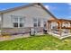 Well-maintained backyard with a patio, pergola, grill, manicured lawn, and stone accents at 8248 S Yantley Ct, Aurora, CO 80016