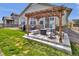 Outdoor patio area with pergola, fire pit, built-in bar, and outdoor seating at 8248 S Yantley Ct, Aurora, CO 80016