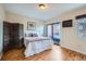 Bright bedroom with wood floors, a balcony and a decorative bicycle painting at 3050 W 32Nd Ave # 202C, Denver, CO 80211