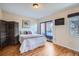 Cozy bedroom featuring wood floors and a sliding glass door to a balcony at 3050 W 32Nd Ave # 202C, Denver, CO 80211