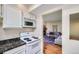 Efficient kitchen with white appliances, dark countertops, and an open view into the living room at 3050 W 32Nd Ave # 202C, Denver, CO 80211