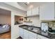 Compact kitchen featuring stainless steel sink, white appliances, and pass-through to the living area at 3050 W 32Nd Ave # 202C, Denver, CO 80211