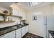 Functional kitchen with white cabinets, stainless steel sink, and black marble countertops at 3050 W 32Nd Ave # 202C, Denver, CO 80211