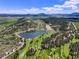 Panoramic aerial view featuring the golf course, lake, mountains, and properties, showcasing the community's amenities at 6100 Apache Dr, Larkspur, CO 80118
