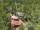 An aerial view of a boulder in a wooded lot with a home nestled among the trees at 6100 Apache Dr, Larkspur, CO 80118