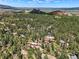 Scenic aerial view of a community surrounded by mature trees and breathtaking rock outcroppings at 6100 Apache Dr, Larkspur, CO 80118