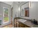 Bathroom with a single sink vanity, black countertop, modern lights and a large mirror at 6100 Apache Dr, Larkspur, CO 80118