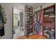 Walk-in closet with custom shelving and organization and adjacent bathroom at 6100 Apache Dr, Larkspur, CO 80118