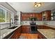 Charming kitchen with granite countertops, wood cabinets, and a modern oven at 6100 Apache Dr, Larkspur, CO 80118
