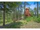 Wooded lot featuring a natural rock formation and a house in the background at 6100 Apache Dr, Larkspur, CO 80118