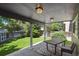 Covered back patio with outdoor table and chairs overlooking a lush backyard with wooden privacy fence at 19653 E Ida Dr, Aurora, CO 80015