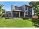 Exterior of home with covered back patio, white trim windows, grey siding, and spacious green lawn at 19653 E Ida Dr, Aurora, CO 80015