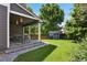 Backyard with covered patio, green lawn, shed, privacy fence, and tree line in a lovely setting at 19653 E Ida Dr, Aurora, CO 80015