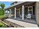Inviting front porch with classic columns, comfortable seating, and landscaped flower bed at 19653 E Ida Dr, Aurora, CO 80015
