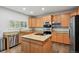 Bright kitchen features wood cabinets, granite countertops, stainless steel appliances, and center island at 19653 E Ida Dr, Aurora, CO 80015