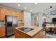 Kitchen with wood cabinets, granite countertops, stainless steel appliances, and island open to a dining area at 19653 E Ida Dr, Aurora, CO 80015