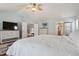 Bright main bedroom features a ceiling fan, tv, and ensuite bathroom access at 19653 E Ida Dr, Aurora, CO 80015