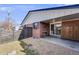 Back exterior features a brick wall, sliding glass door, gravel and grass landscaping at 1166 Krameria St, Denver, CO 80220