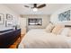 A bright bedroom with light walls, a ceiling fan, a large window, and a dark wood dresser at 1166 Krameria St, Denver, CO 80220