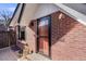 Charming brick home with a red-framed glass front door and adjacent window with black trim at 1166 Krameria St, Denver, CO 80220