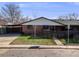Charming brick home with a well-maintained lawn, partial fence and a covered parking area at 1166 Krameria St, Denver, CO 80220