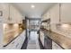 Modern kitchen with white cabinets, stone countertops, and stainless steel appliances at 1166 Krameria St, Denver, CO 80220