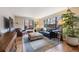 Comfortable living room with a black leather couch, matching armchair, large windows and hardwood floors at 1166 Krameria St, Denver, CO 80220
