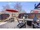 Outdoor patio features a paver patio, dark wood fence, fire pit, grill, seating, and an orange umbrella at 1166 Krameria St, Denver, CO 80220