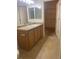 Well-lit bathroom with wood vanity and mirrors at 9300 E Florida Ave # 608, Denver, CO 80247