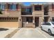 A front exterior view of a tan two-story townhome with a garage and a balcony under a clear blue sky at 9300 E Florida Ave # 608, Denver, CO 80247
