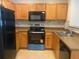 Kitchen featuring oak cabinets, black appliances, and a light colored countertop at 9300 E Florida Ave # 608, Denver, CO 80247