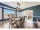 Elegant dining room featuring a chandelier, hardwood floors, and large windows, adjacent to living area at 7119 S Riviera St, Aurora, CO 80016