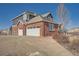 Two-car garage and side view of the brick home at 7119 S Riviera St, Aurora, CO 80016