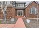 Charming brick home featuring a walkway to a covered porch, double doors, and a combination of gray and brick exteriors at 7119 S Riviera St, Aurora, CO 80016
