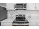 Close-up of the range, microwave, and countertops of an updated kitchen with stainless steel appliances at 2232 Coronado Pkwy # B, Denver, CO 80229