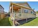 Backyard of a tan home featuring a covered patio and a well-maintained lawn at 5425 E 125Th Pl, Thornton, CO 80241