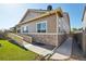 Exterior of a tan home featuring stone accents, a ramp, and a well-maintained lawn at 5425 E 125Th Pl, Thornton, CO 80241