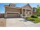 A charming home featuring stone accents, a covered front porch, an attached garage, and a well-manicured lawn at 5425 E 125Th Pl, Thornton, CO 80241